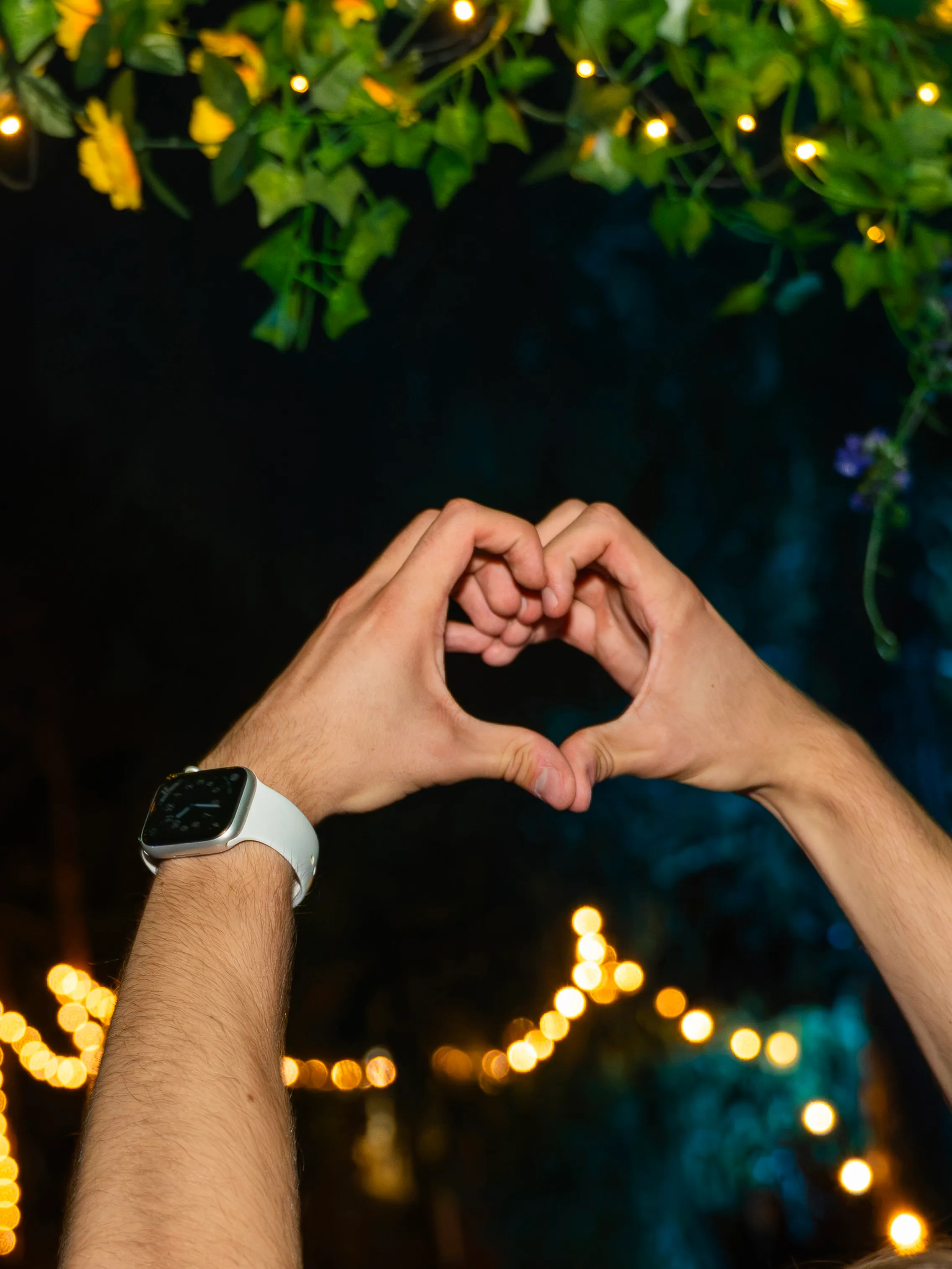 Hands forming a heart, festival lights